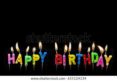 Colorful happy birthday candles on black background