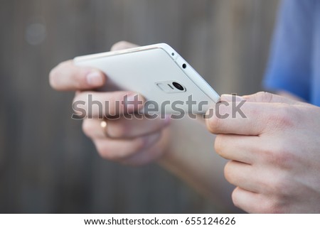 A man takes pictures on a smartphone. Close-up of hand and gadget in a horizontal position