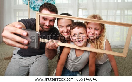 Young happy family father making selfie on a smartphone at home