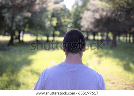 Lonely short haired guy walking in the park