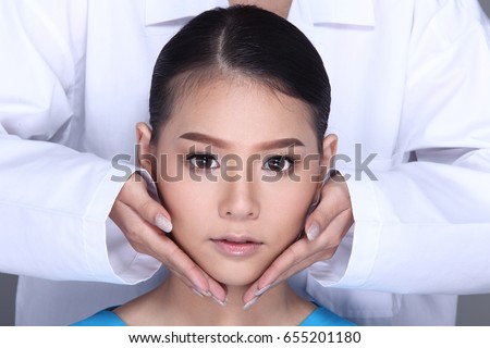 V Shape Face Checking diagnose by Beautician Doctor, put hands on patient face. Studio lighting white background isolated Royalty-Free Stock Photo #655201180