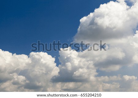  cumulus clouds that are in the blue sky. Picture with a shallow depth of field
