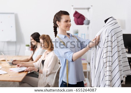 Charming young woman checking cardigan lapels