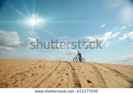 Alone rider on fixed gear road bike riding in the desert, tourist bicycle rider pictures.