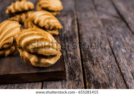 Traditional shortbread cookies with caramel filling on a wooden background. Selective focus.