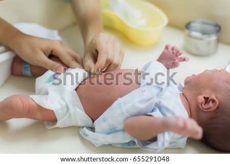 Mother is cleaning the navel of a newborn baby. Royalty-Free Stock Photo #655291048