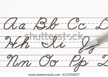 Learning to write cursive lettering, Samples of cursive lettering on lined paper with a pen Royalty-Free Stock Photo #655294837