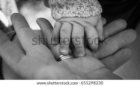 Three generations of men father baby son and grandfather hands together in black and white family photo Royalty-Free Stock Photo #655298230