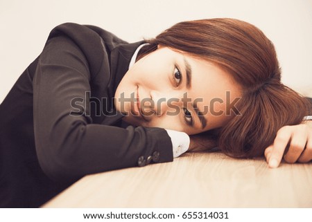 Pretty young Asian businesswoman lying on table