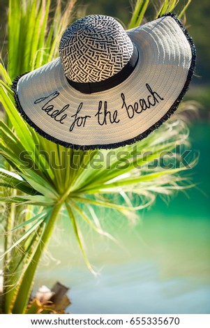 Beautiful beach. View of nice tropical beach with palms around. Holiday and vacation concept. Tropical. Straw hat on the beach.