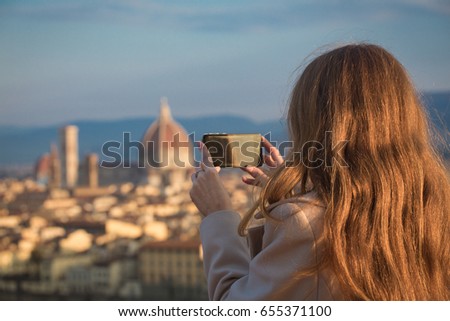 girl making a photo shoot of Florence with the smartphone 
