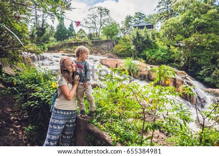 Mother and son on the background of Beautiful Camly waterfall In Da Lat city,