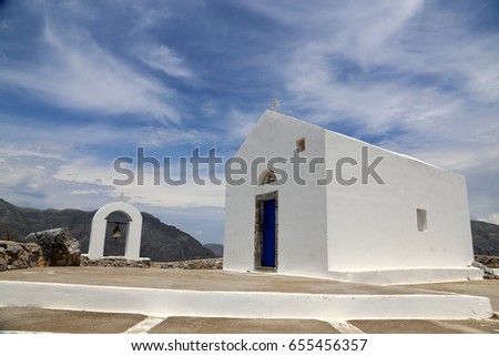 A little whitewashed chapel on top of the local moutain Timeos Stavros(440 metres high) overlooking the bays of Damnoni, Spili and Plakias under a blue sky with decorative clouds; Crete, Greece