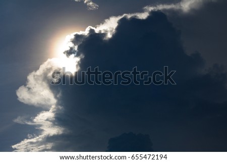 Sun hiding behind a cloud on the day sky with copy space. Long lasting concept