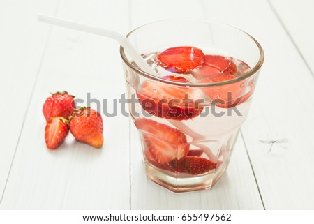 Fruit water in a glass on a white table. Organic strawberry.