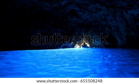A silhouette of a boat at the exit of Blue grotto cave, Capri, Italy Royalty-Free Stock Photo #655508248