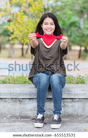 Asian woman hand hold beautiful red heart sweet loving symbol of take care or charity help to you.