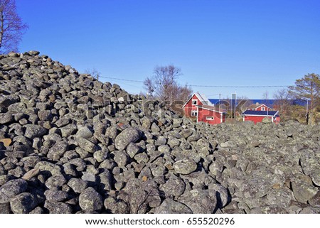 Huge pile of stones and old fishing village buildings.