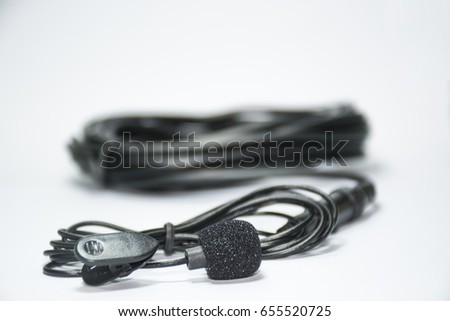 tie-clip on microphone , black color , white background , close up