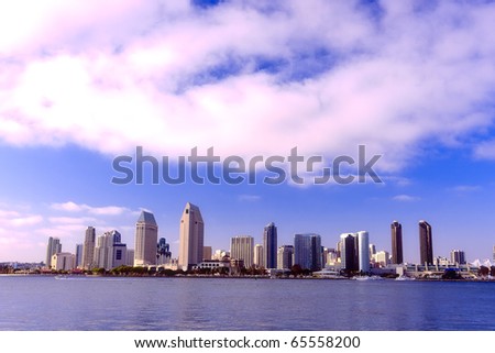 San Diego city skyline at sunset, showing the buildings of downtown rising above harbor viewed from Coronado Island.