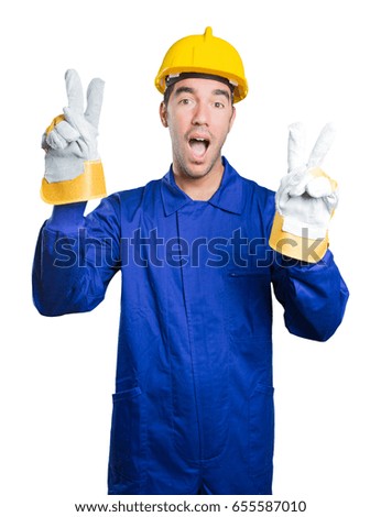 Winner workman with victory gesture on white background