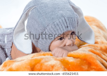 Newborn baby lying on fur looking curious.
