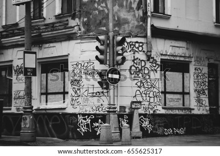 Ghetto street of the city painted graffiti. Dirty walls in the inscription. Traffic light stop sign. Royalty-Free Stock Photo #655625317