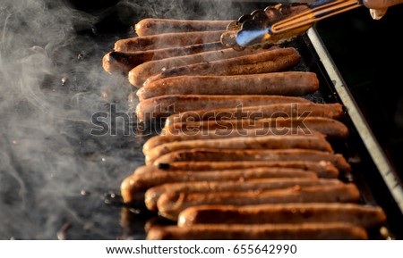 Sausages sizzling on hot barbecue Royalty-Free Stock Photo #655642990