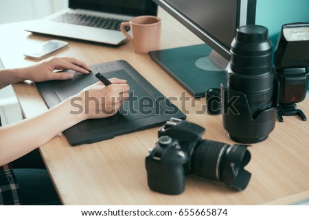 closeup of professional young female photo designer using digital pen drawing retouch photographer business picture working on editing office desk.
