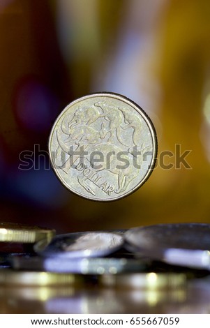 Australian dollar falling onto a bed of coins.