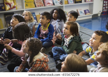 Kindergarten students sitting on the floor Royalty-Free Stock Photo #655672276