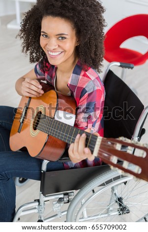 Lady in wheelchair playing guitar