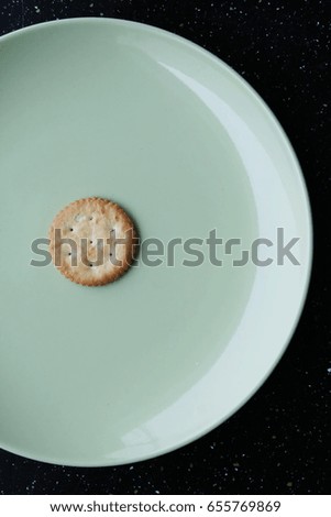 biscuit cracker on white plate with tea spoon