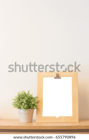 Mock up wooden frame and plant on book shelf or desk.