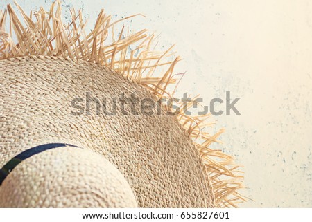 Straw hat on a concrete background in sunlight.