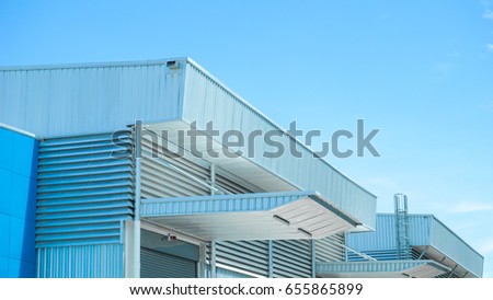 Factory warehouse and industrial concept - Wall and roof of Factory or warehouse building in industrial estate with blue sky and copyspace