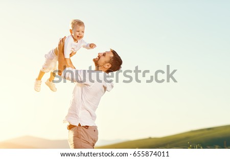 Father's day. Happy family father and toddler son playing and laughing on nature at sunset
