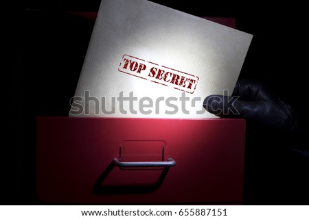 Looking for top secret documents in a dark. Royalty-Free Stock Photo #655887151
