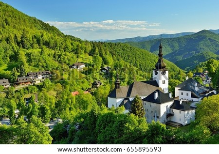 Spring in Slovakia. Old mining village. Historic church in Spania dolina. Springtime colored trees at sunset. Royalty-Free Stock Photo #655895593