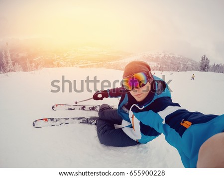Guy sportsman goes on the normal skiing on the ski slope with the action camera. Sunset. Sheregesh, Kemerovo region, Russia.