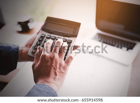 Man using calculator,finance and economy concept through a laptop.