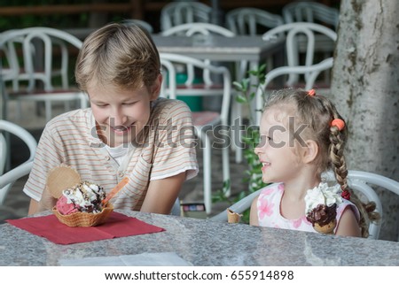 Two siblings are having fun eating their sweet Italian gelato ice cream