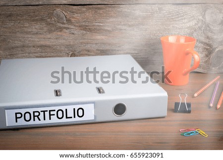 Portfolio. Folder, Coffee Mug and colored pencils on wooden office desk
