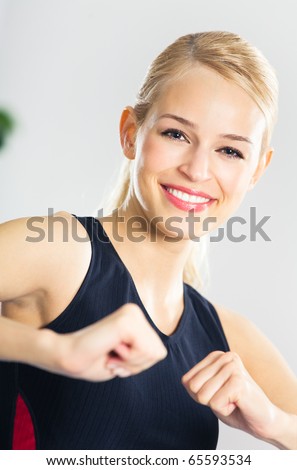 Portrait of young woman in sportswear, doing fitness exercise, indoors