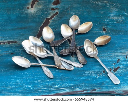 old teaspoons on a blue wooden table, selective focus and toned image
