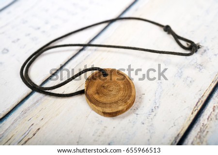 Wooden rustic necklace for men on white wooden background