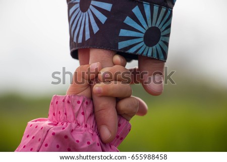 Mother and daughter holding hands. Toghter forever.