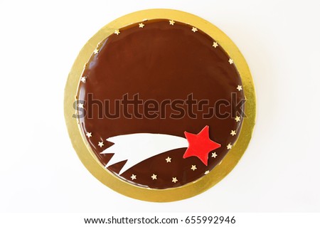 A birthday cake poured with chocolate, decorated with confectionery sprinkling stars and a comet image on a yellow and white background. Picture for a menu or a confectionery catalog. Top view.