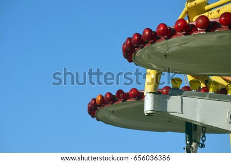Bright lights against blue sky at carnival amusement park 
