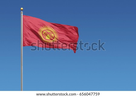 Kyrgyzstan flag in front of a clear blue sky